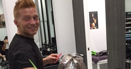 Man smiling while cutting a customers hair