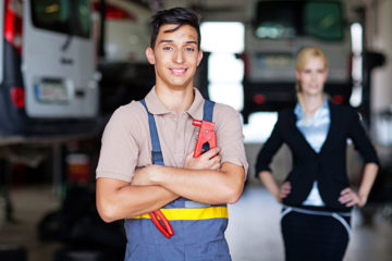 Man posing for photo in work overalls and holding tools