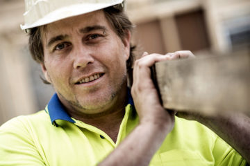 Tradesman holding a plank of wood
