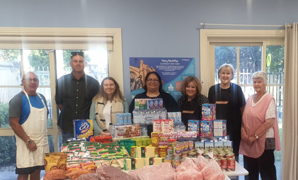 Group of people posing with donated food for Mary Mac's Place
