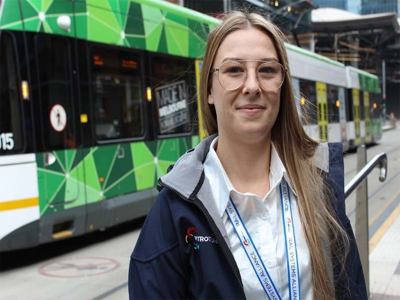 Lady standing in front of Melbourne tram